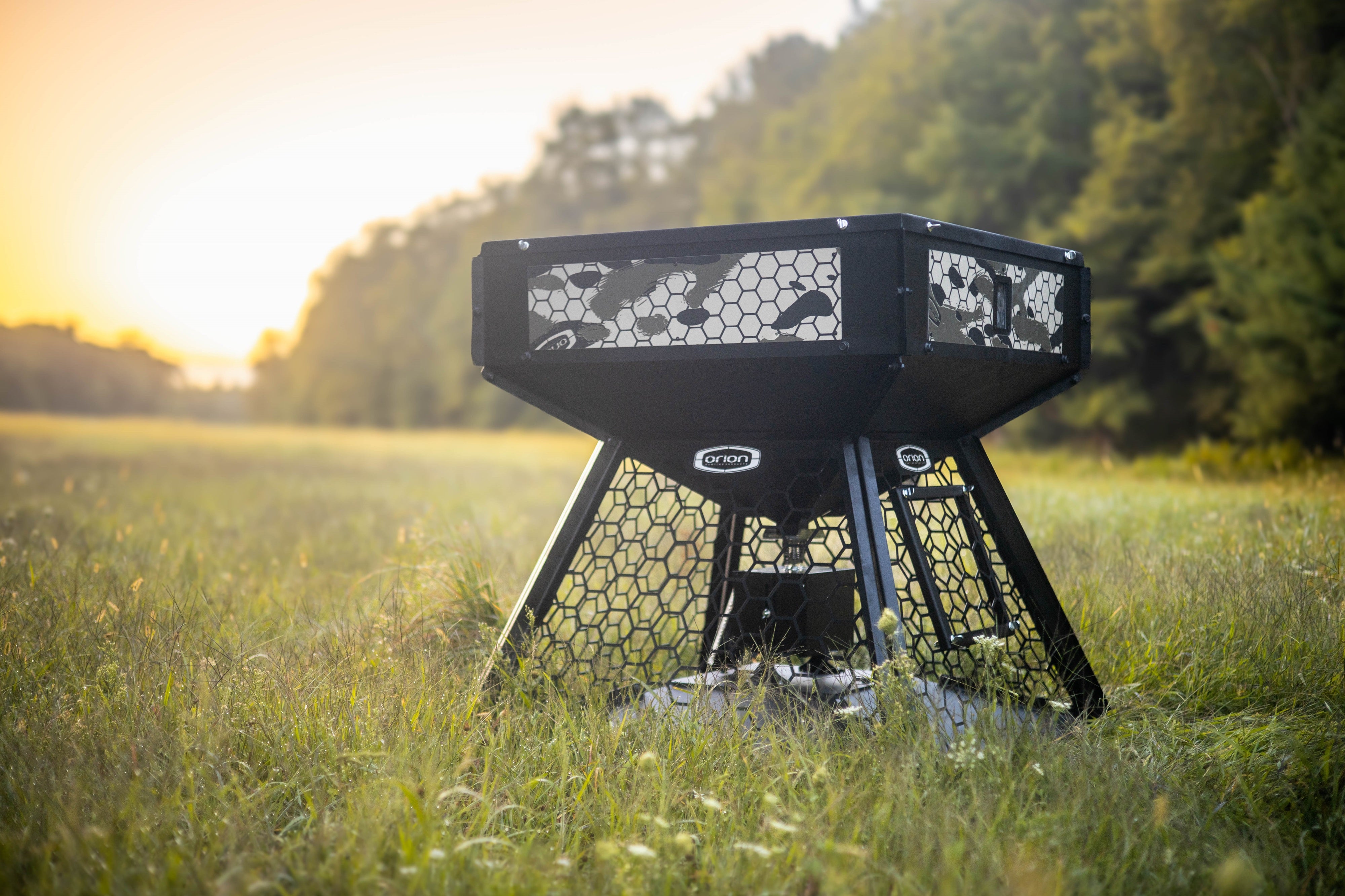 Orion 450lbs modular stand and fill deer feeder featuring a bear and hog proof hexagonal cage in an open field