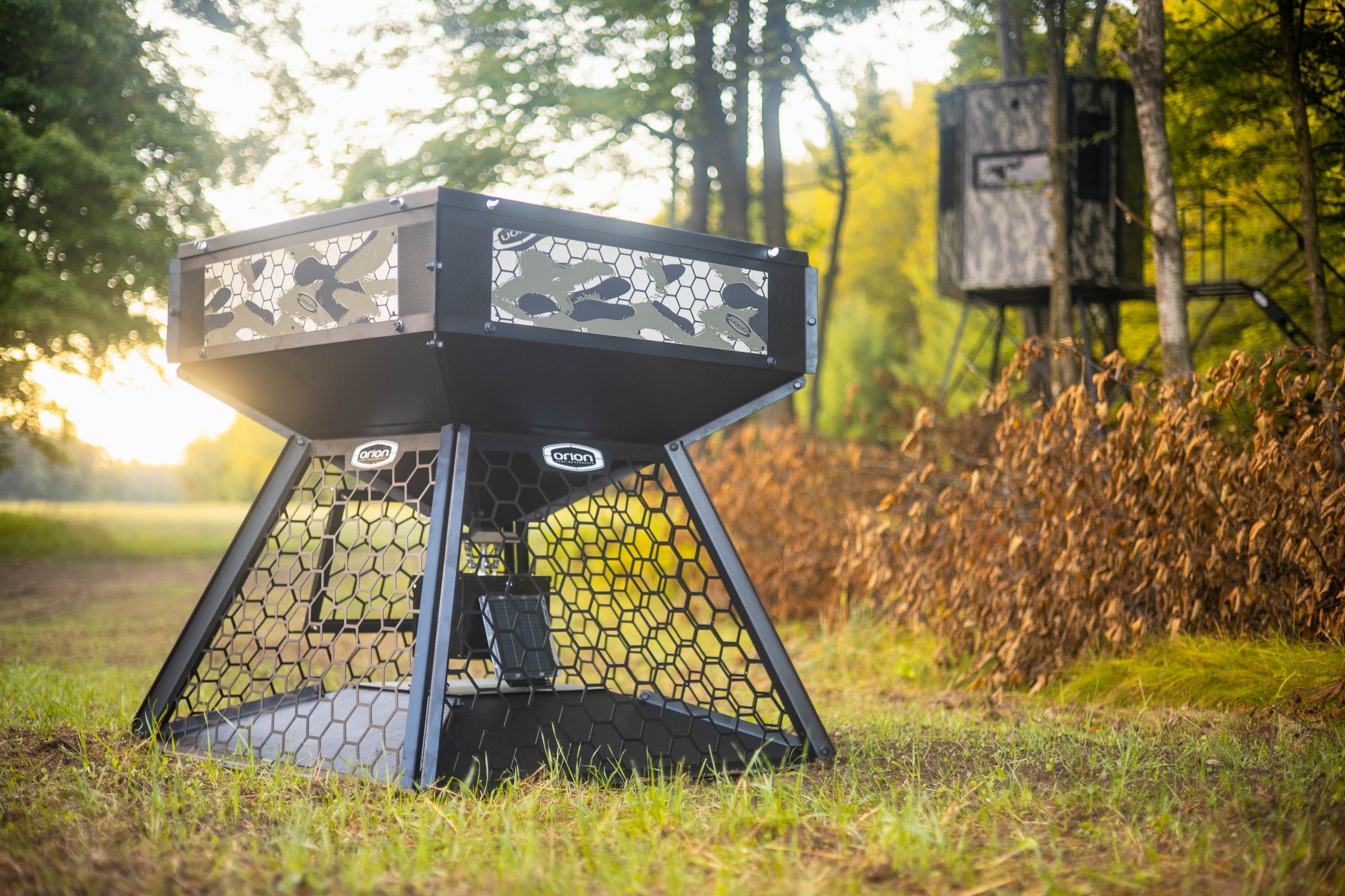 Orion 450lbs modular stand and fill deer feeder featuring a bear and hog proof hexagonal cage in an open field